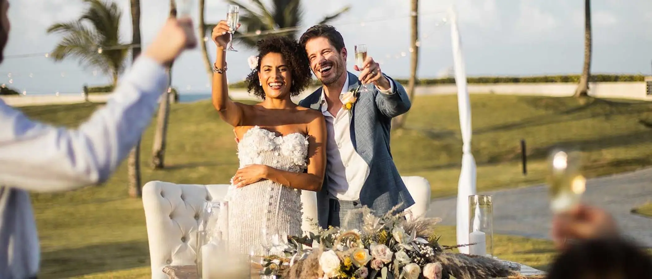 Bride and groom raising a champagne toast at an outdoor reception, Hard Rock Riviera Maya