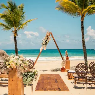 Boho beachfront wedding ceremony with triangular arch at Hard Rock Cancun