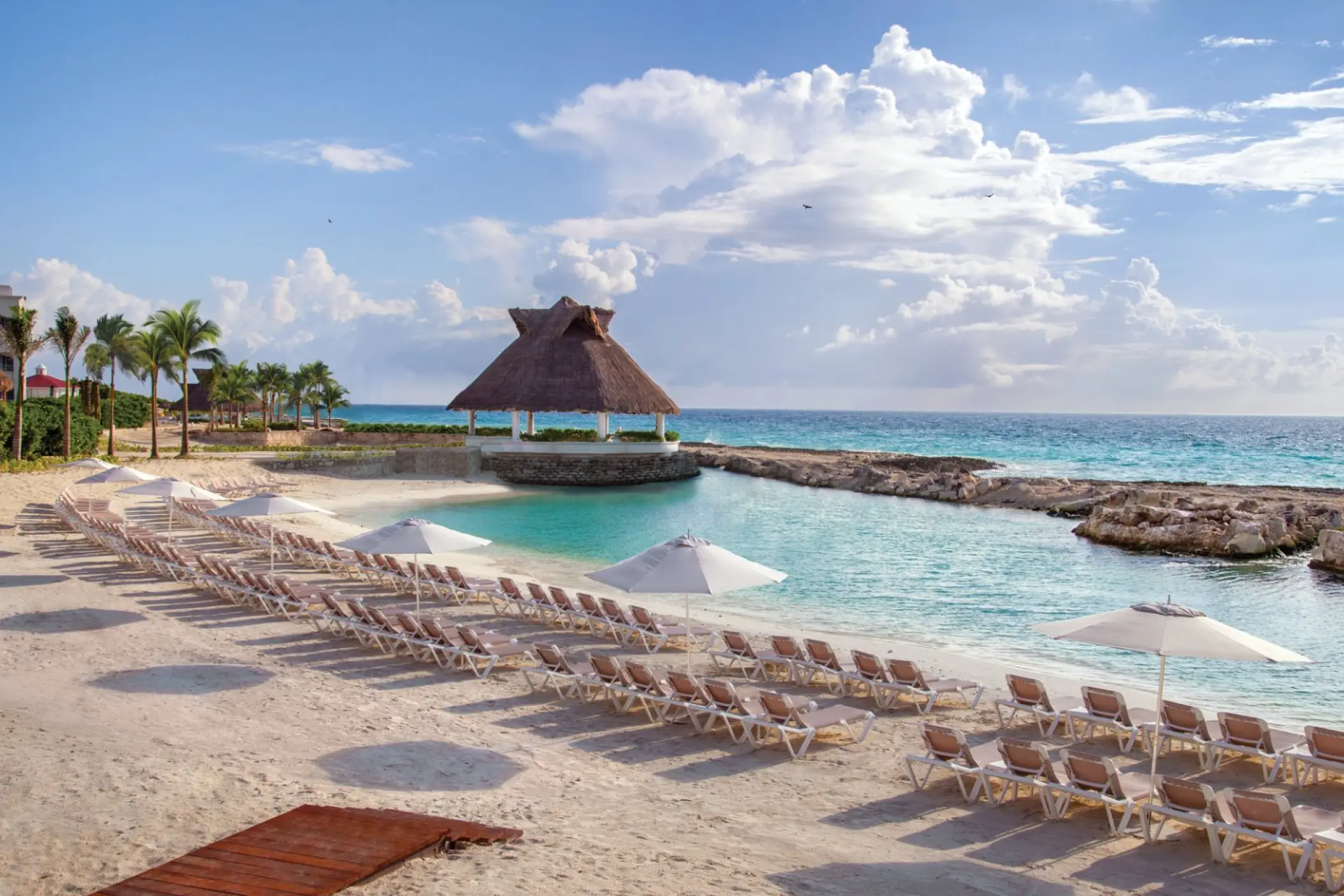 Private beach cove with sun loungers and a thatched gazebo at Hard Rock Riviera Maya