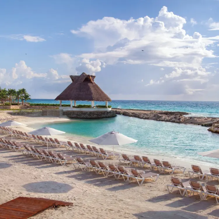 Private beach cove with sun loungers and a thatched gazebo at Hard Rock Riviera Maya