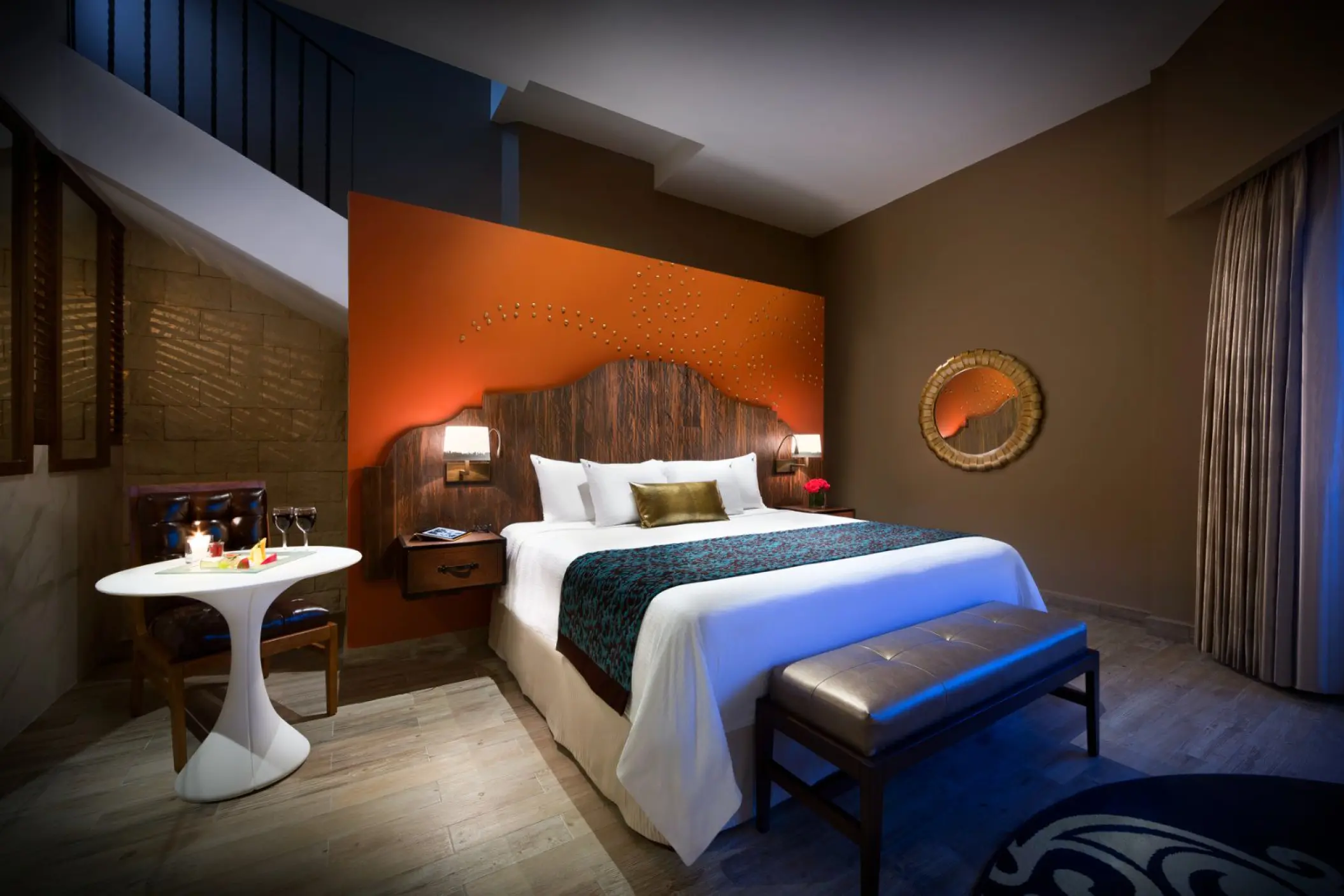 Modern suite with orange accent wall and king bed at Hard Rock Hotel Riviera Maya