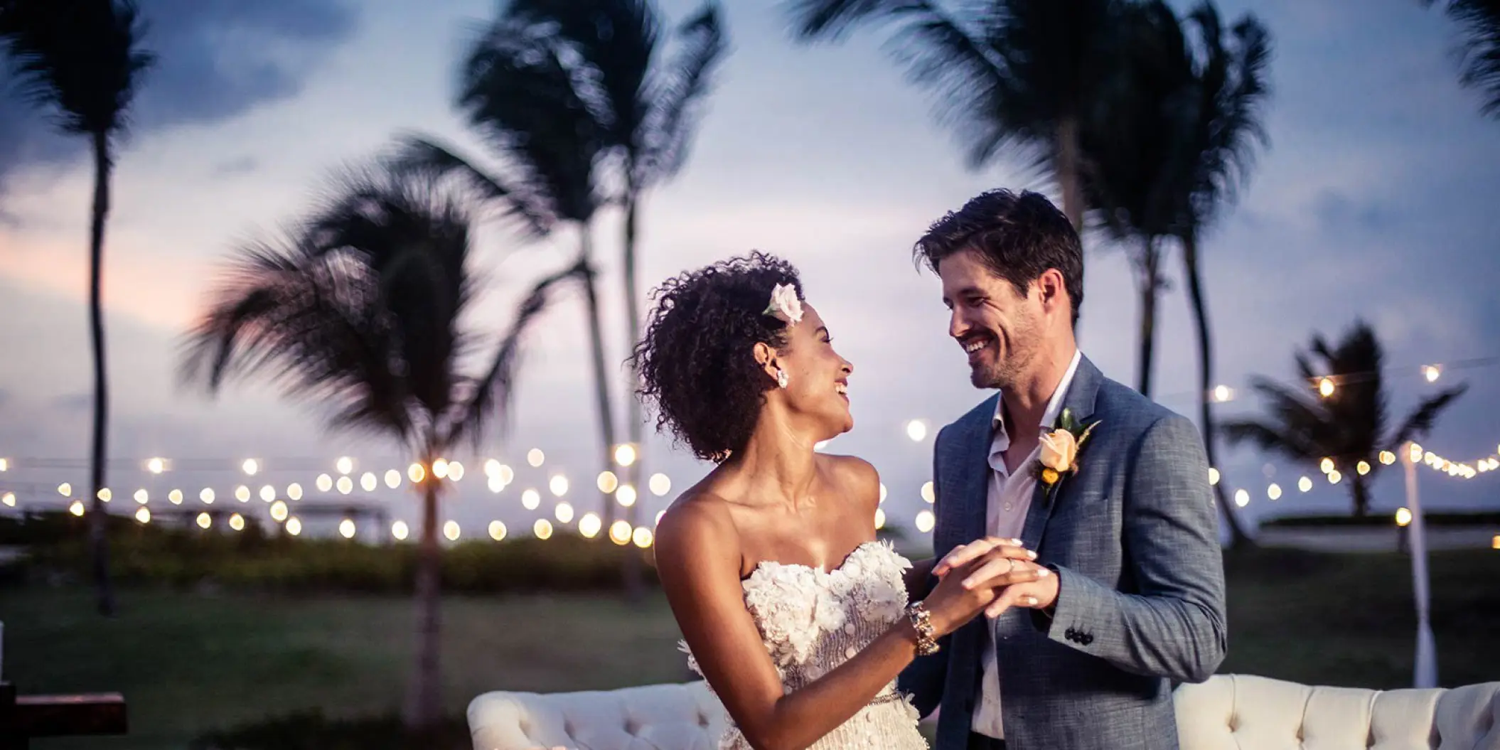 The bride and groom dancing at an outdoor wedding reception under string lights at Hard Rock Cancun