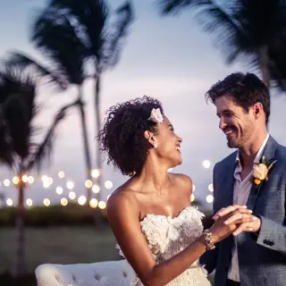 The bride and groom dancing at an outdoor wedding reception under string lights at Hard Rock Cancun