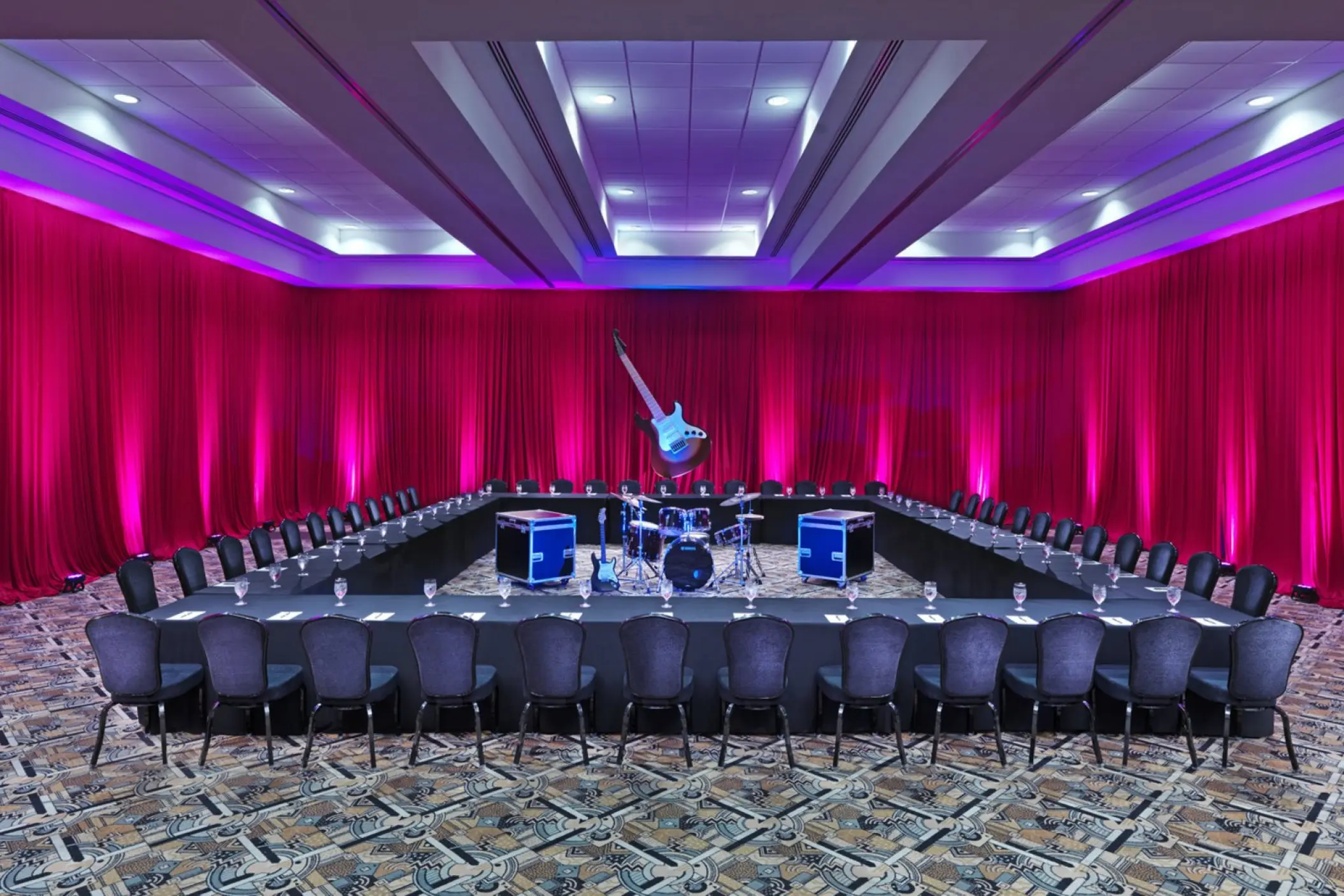 Indoor meeting room with red curtains and a rock band setup at Hard Rock Riviera Maya