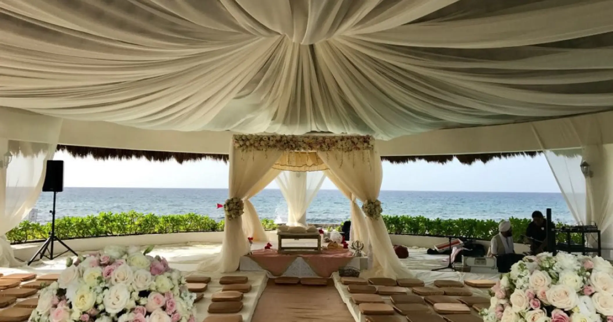 Draped oceanview ceremony setup with floor seating at Hard Rock Riviera Maya, Riviera Maya