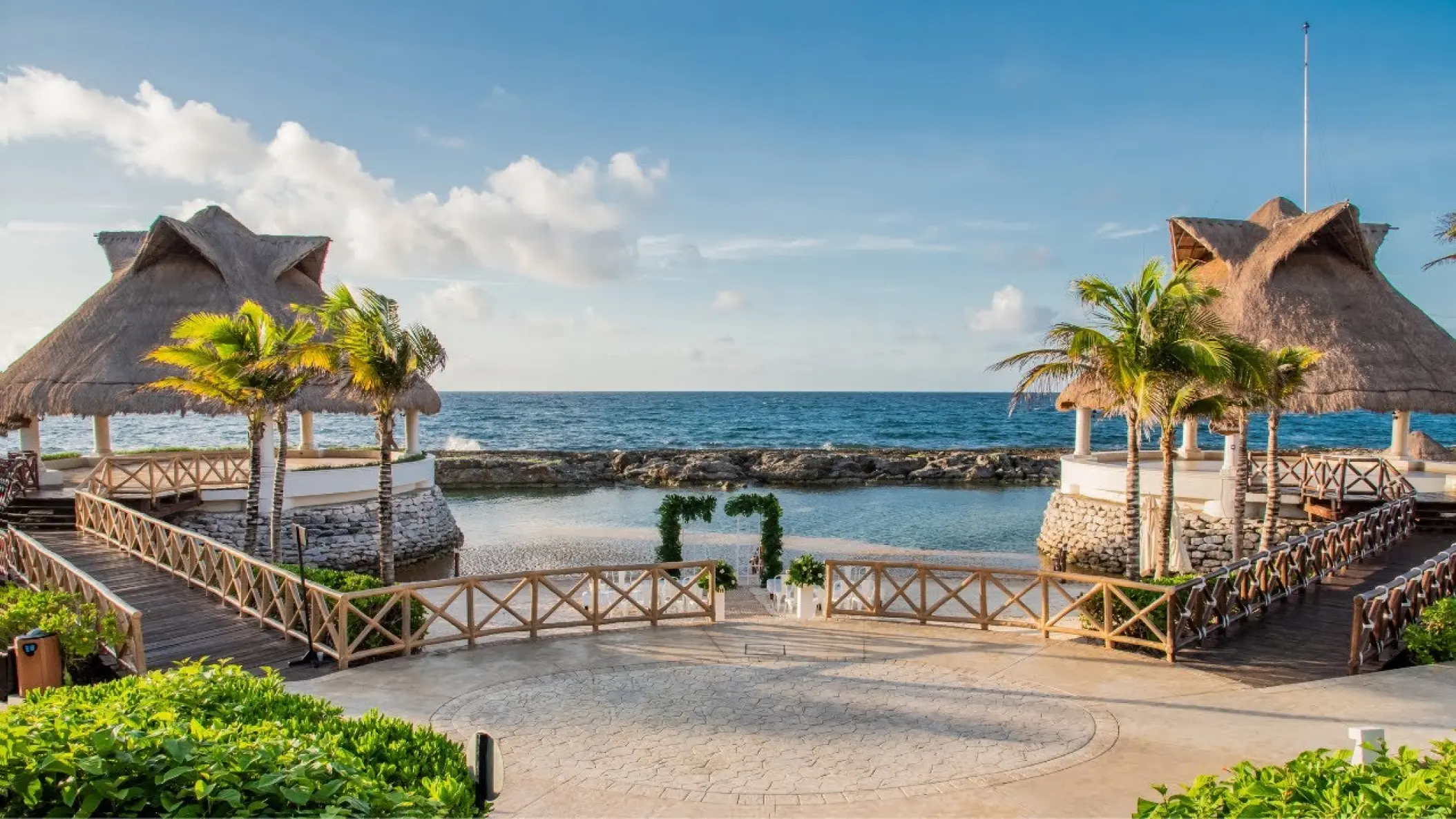 Beachfront wedding ceremony setup between two palapas at Hard Rock Riviera Maya