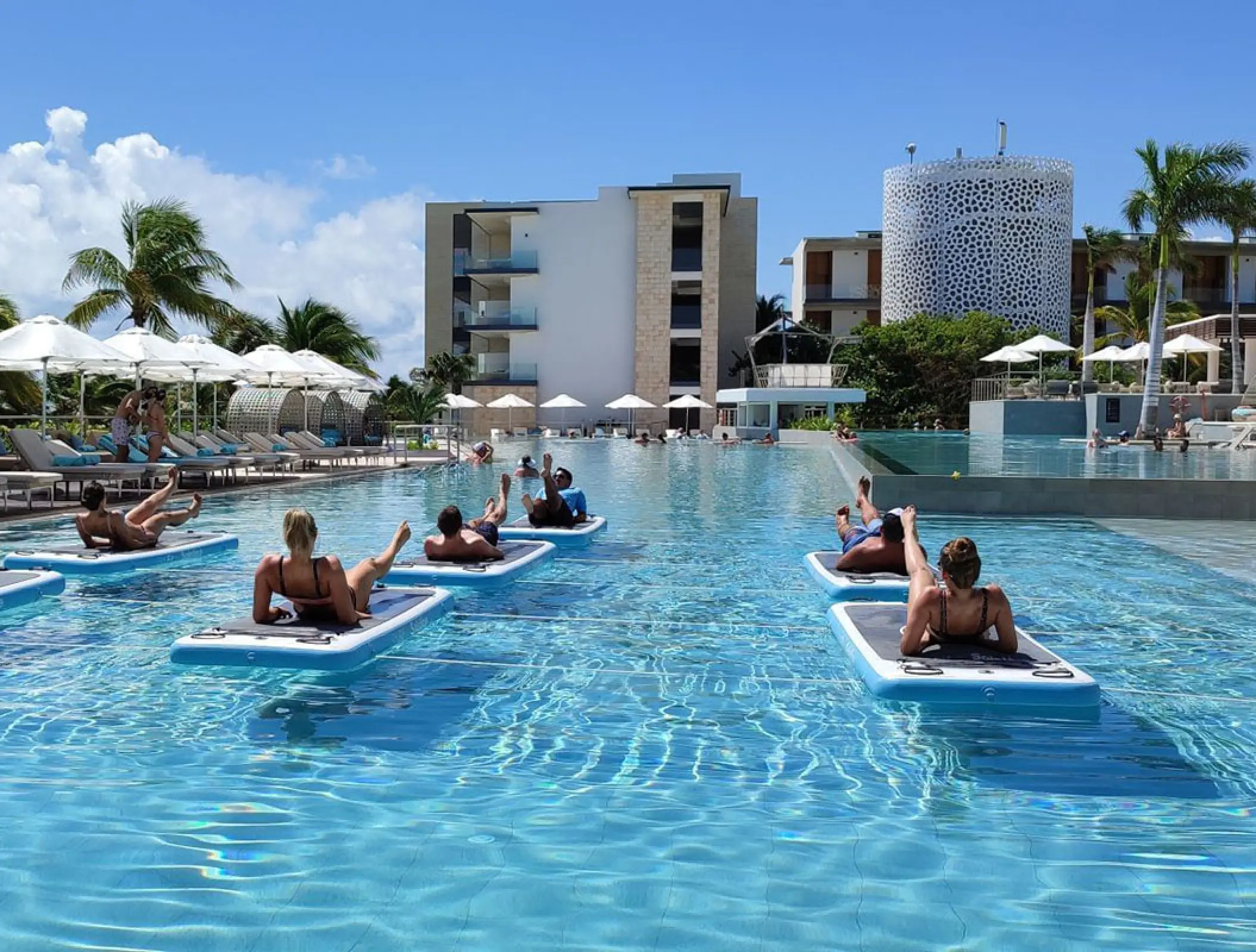 Guests participating in a pool fitness class on floating mats at Haven Riviera Cancun, Riviera Maya