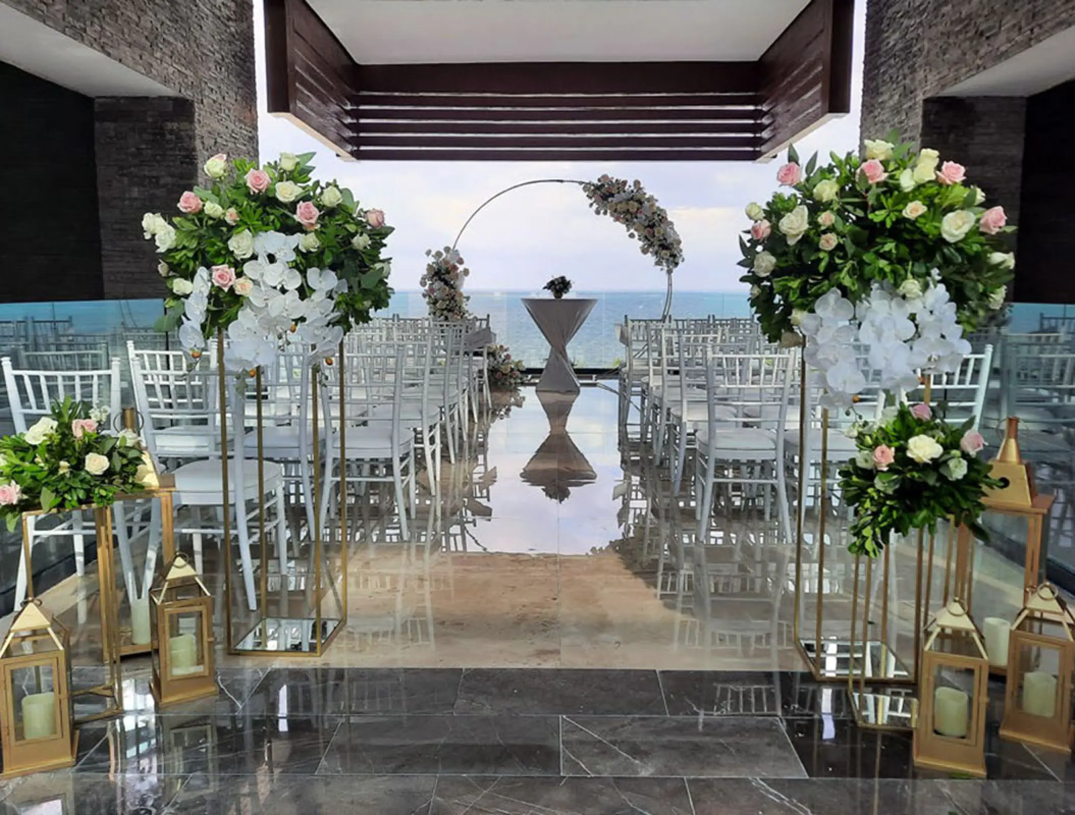 Rooftop wedding ceremony setup with floral arrangements and ocean views at Haven Riviera Cancun, Riviera Maya