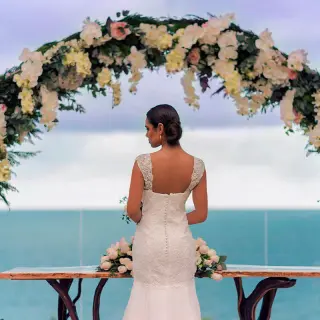 Bride standing under a floral arch for a terrace wedding ceremony at Haven Riviera Cancun, Riviera Maya