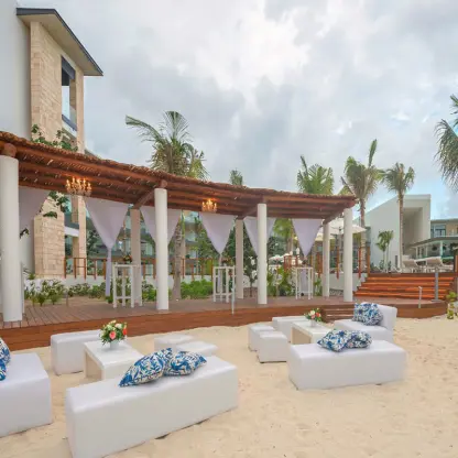 Beachfront wedding reception lounge with white seating and a wooden terrace at Haven Riviera Cancun, Riviera Maya