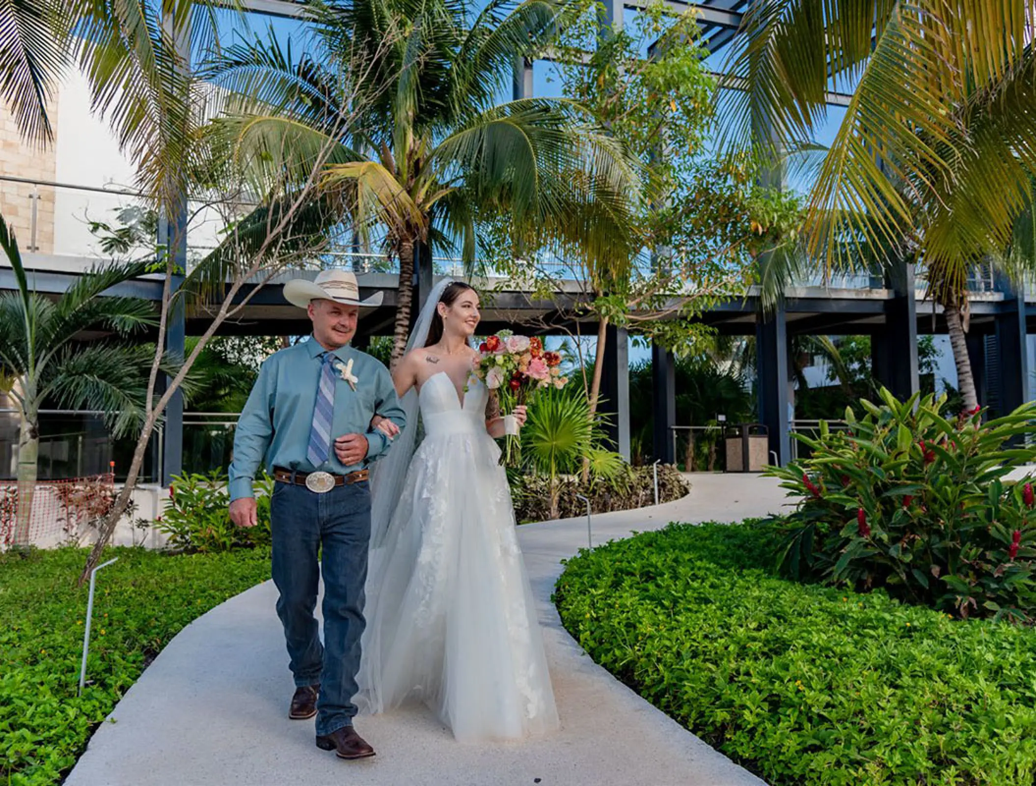 Bride walking down the aisle garden path with her father at Haven Riviera Cancun, Riviera Maya