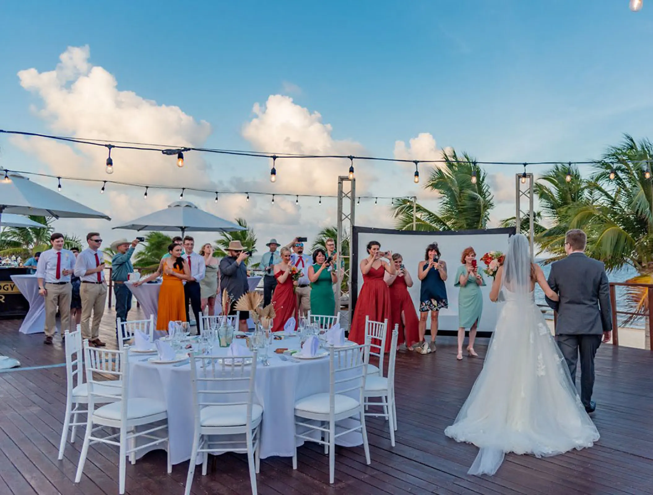 Bride and groom entering their outdoor wedding reception on Vora Deck at Haven Riviera Cancun