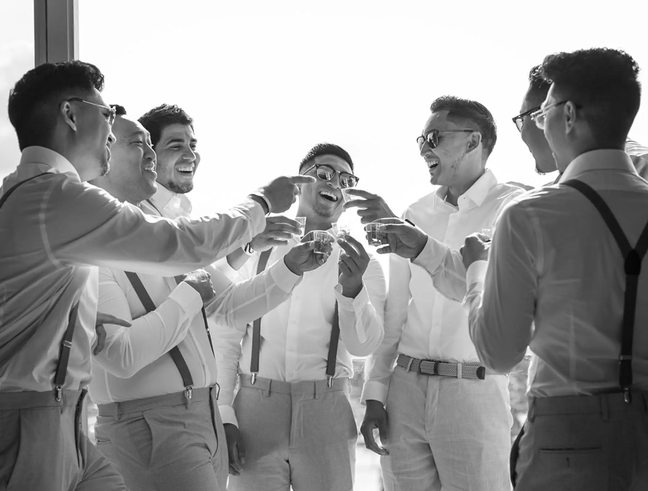 Groomsmen sharing a toast in black and white at Haven Riviera Cancun