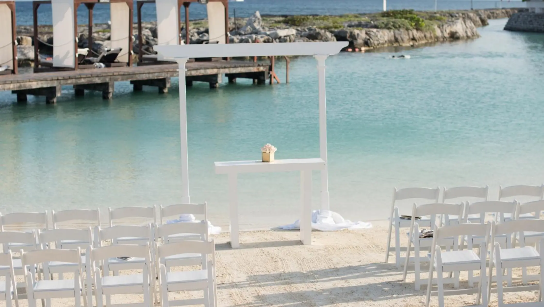 White beach ceremony setup by the cove at Hard Rock Riviera Maya