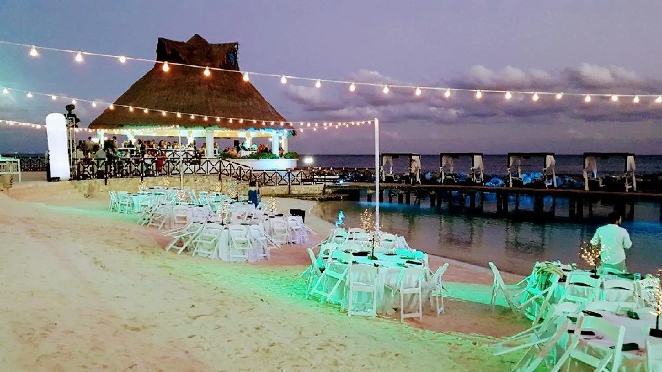 Beachfront wedding reception setup with string lights at Hard Rock Riviera Maya