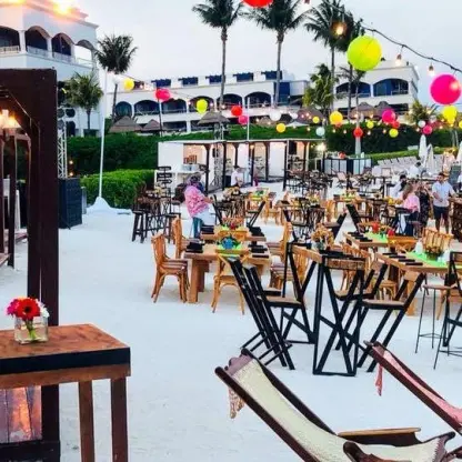 Outdoor wedding reception with colorful lanterns and wooden tables at Hard Rock Riviera Maya