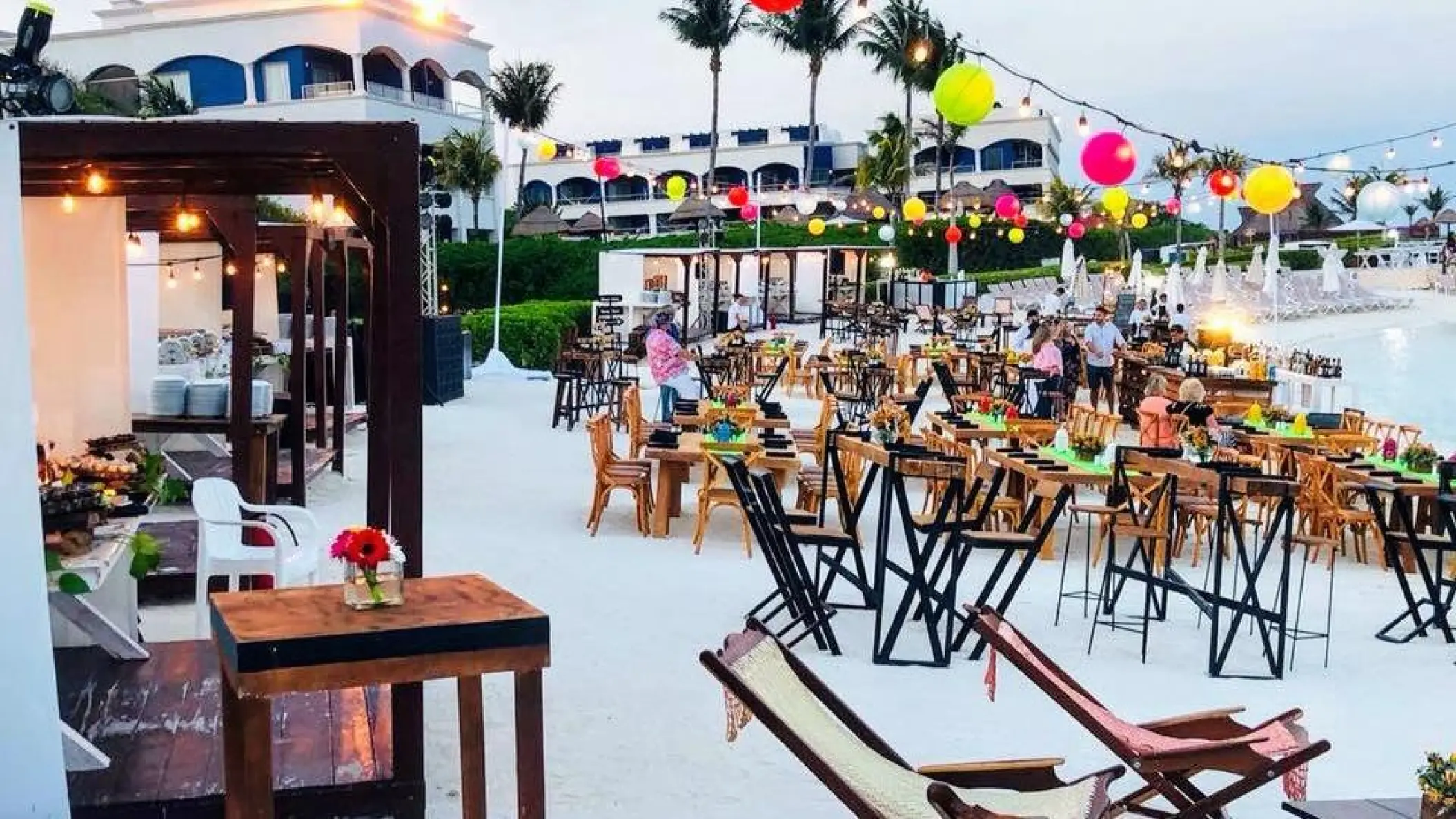 Outdoor wedding reception with colorful lanterns and wooden tables at Hard Rock Riviera Maya