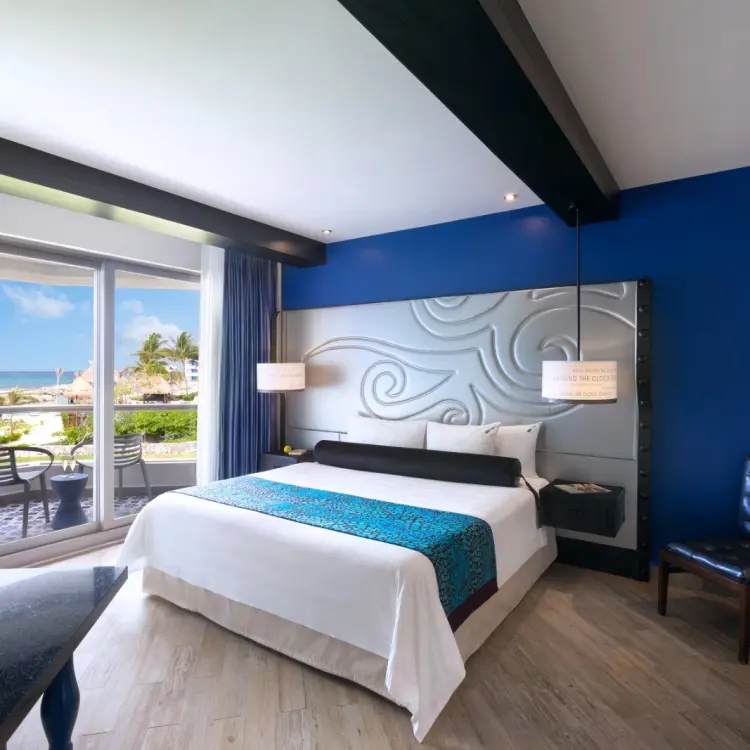 King bedroom with blue accent wall and balcony at Hard Rock Riviera Maya