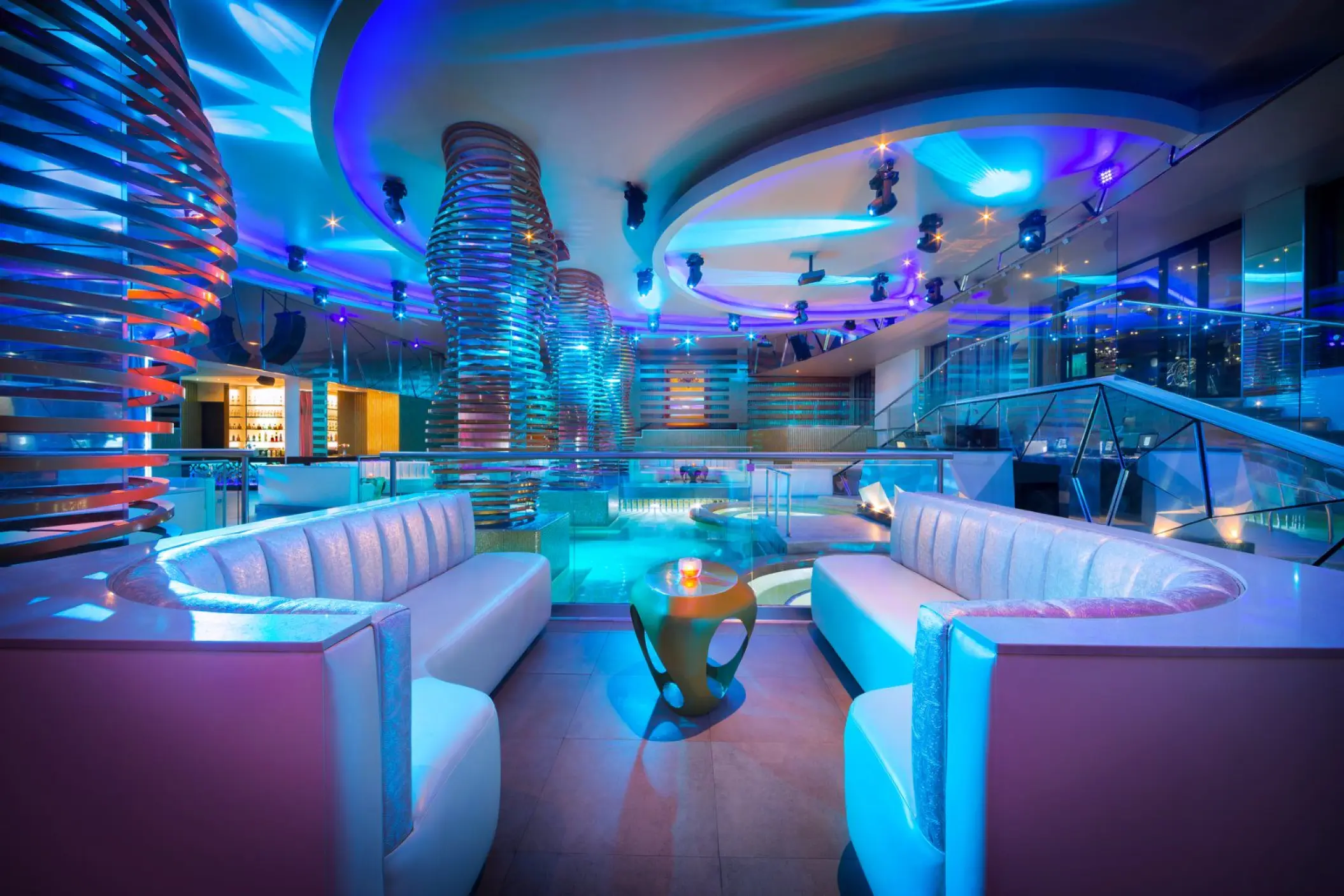 Modern nightclub lounge with neon blue lighting and white leather booths at Hard Rock Riviera Maya