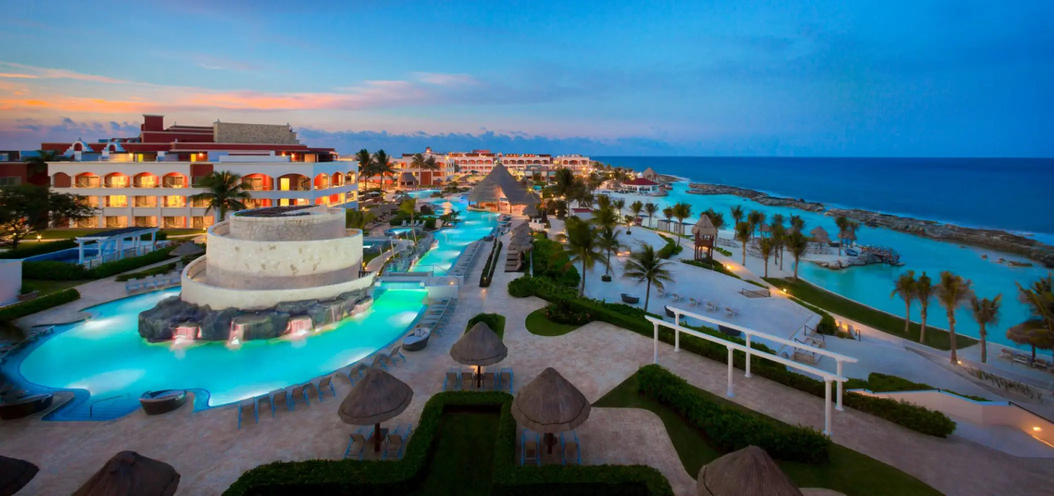 Aerial view of swimming pools and beach lagoons at dusk at Hard Rock Riviera Maya