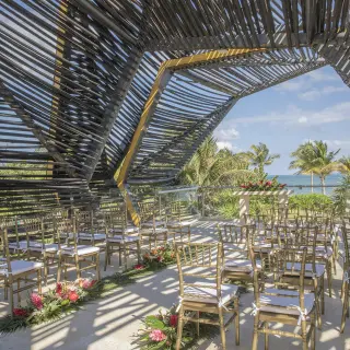 Terrace wedding ceremony under a geometric wooden canopy at Royalton Riviera Cancun