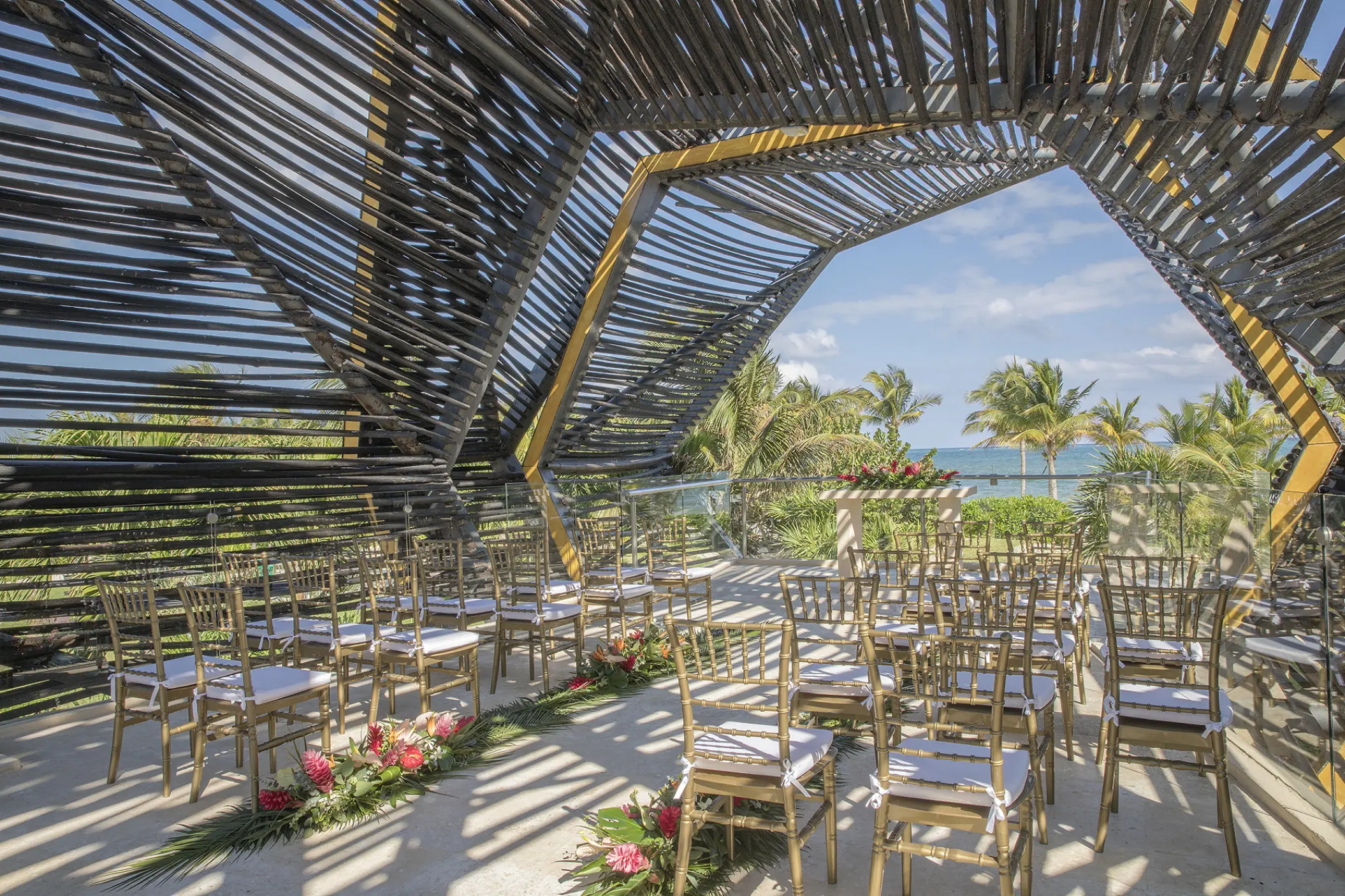 Terrace wedding ceremony under a geometric wooden canopy at Royalton Riviera Cancun