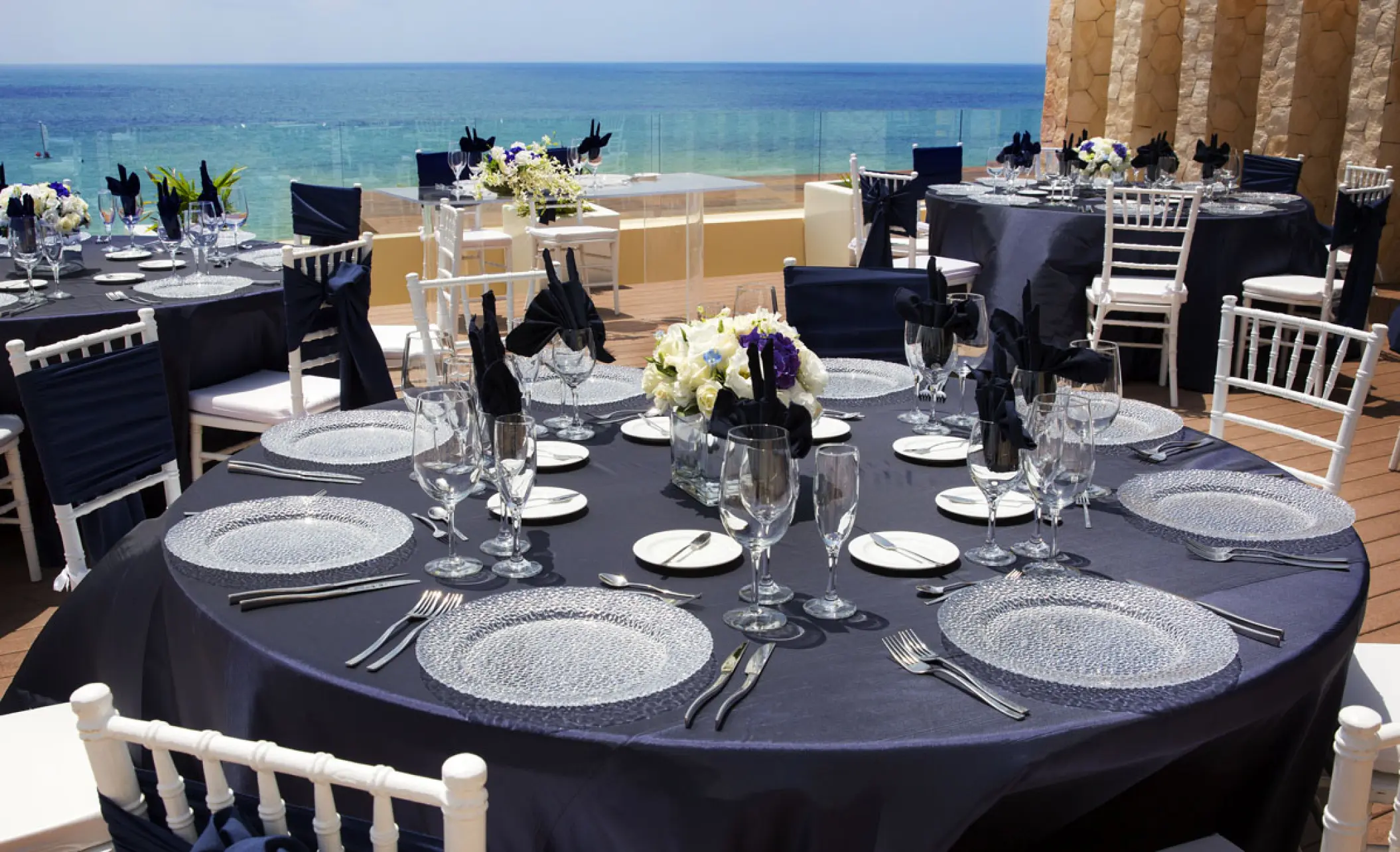 Outdoor wedding reception with navy linens and ocean views at Royalton Riviera Cancun