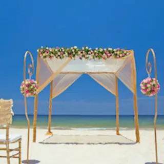 Beachfront wedding ceremony with a floral huppah at Royalton Hideaway Riviera Cancun, Cancun