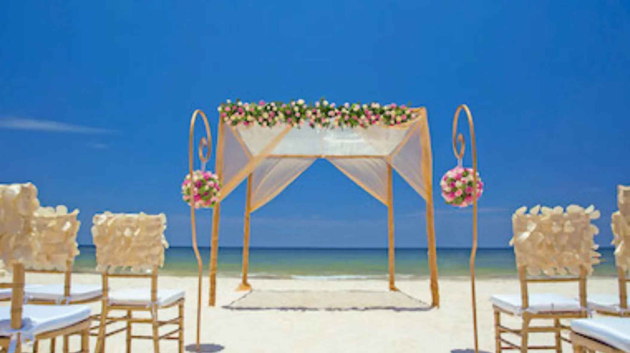 Beachfront wedding ceremony with a floral huppah at Royalton Hideaway Riviera Cancun, Cancun