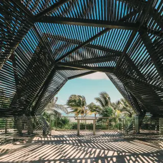 Modern slatted wood wedding chapel overlooking palm trees at Royalton Riviera Cancun