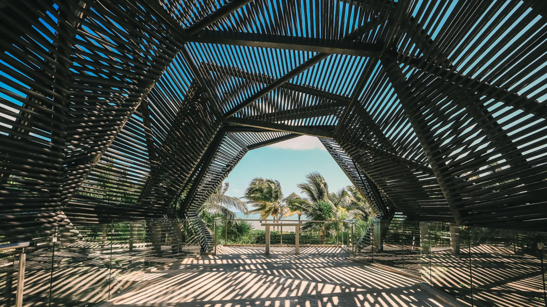 Modern slatted wood wedding chapel overlooking palm trees at Royalton Riviera Cancun