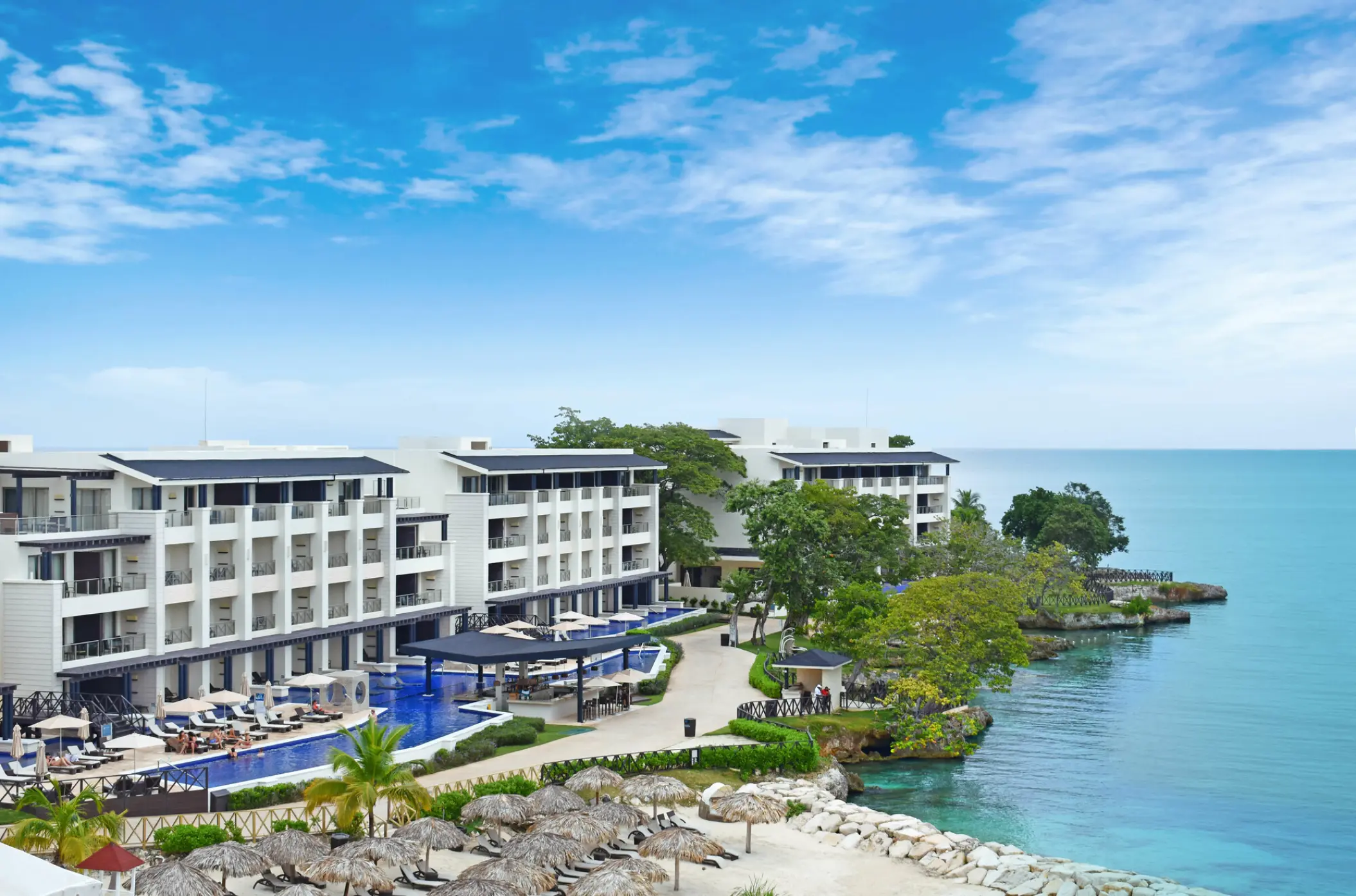 Aerial view of Royalton Hideaway Negril oceanfront buildings and swim-up pools along the coast, Negril
