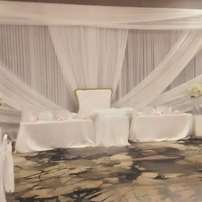 Indoor ballroom wedding reception with white fabric draping and floral centerpieces at Royalton Hideaway Negril