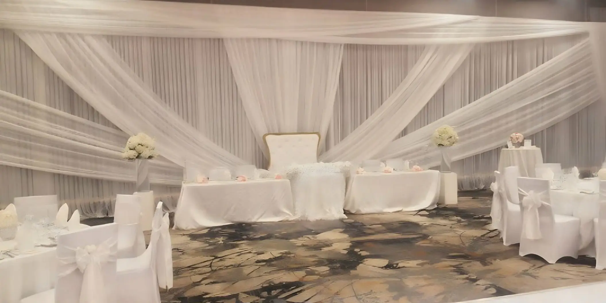 Indoor ballroom wedding reception with white fabric draping and floral centerpieces at Royalton Hideaway Negril