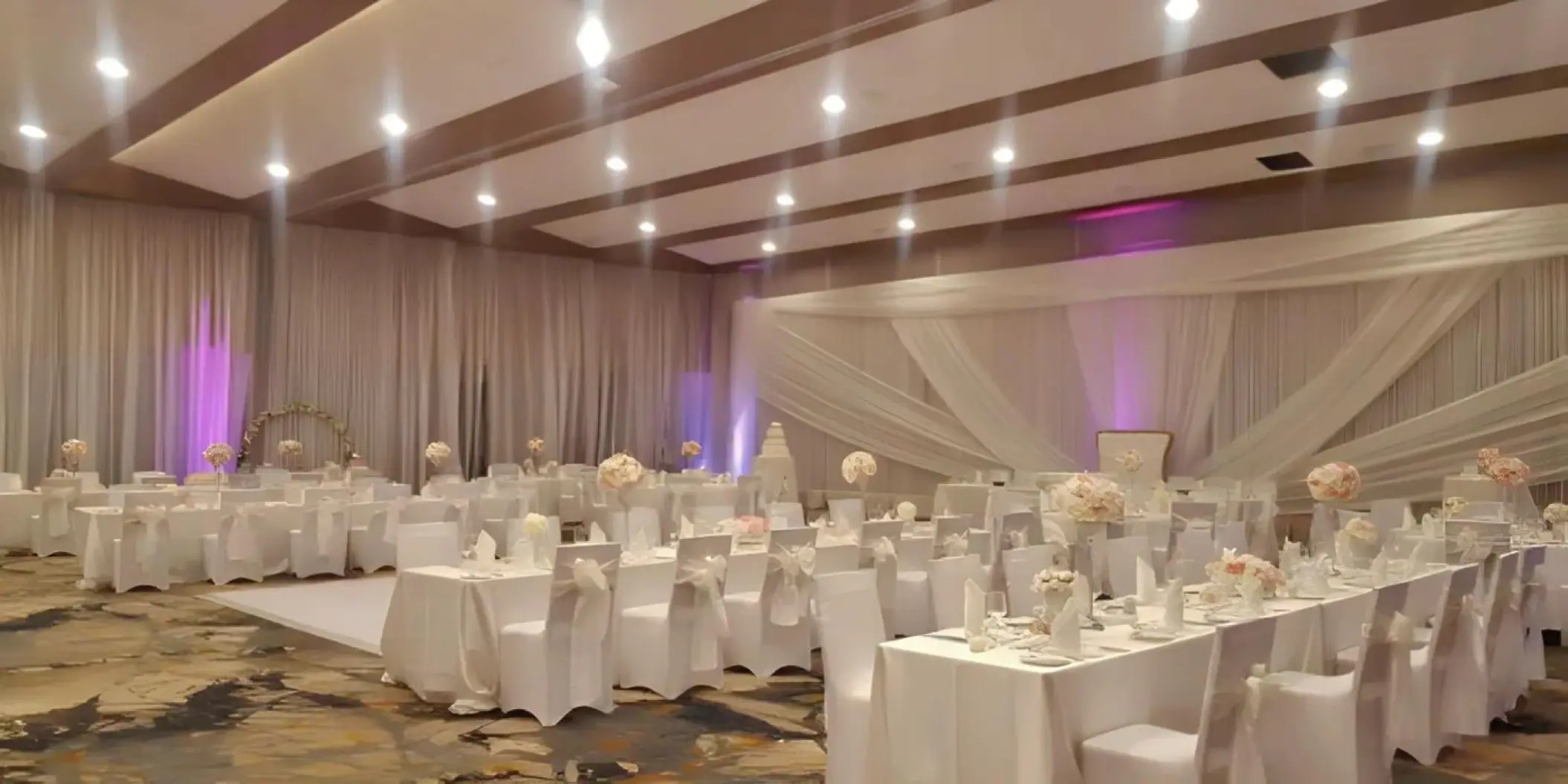Indoor ballroom wedding reception with white linens and draped fabric at Royalton Hideaway Negril, Negril