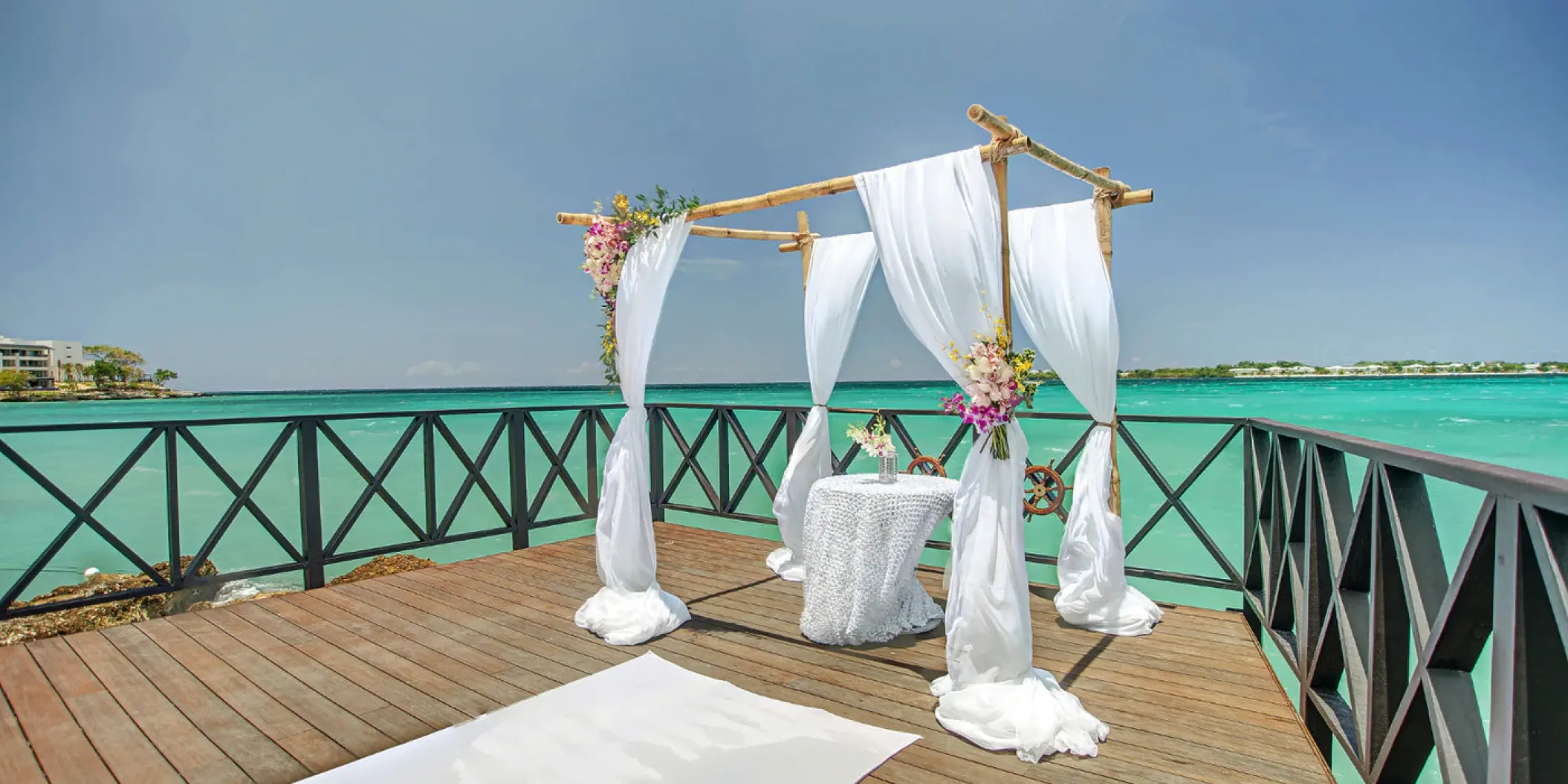Ocean pier wedding ceremony setup with a bamboo huppah at Royalton Hideaway Negril