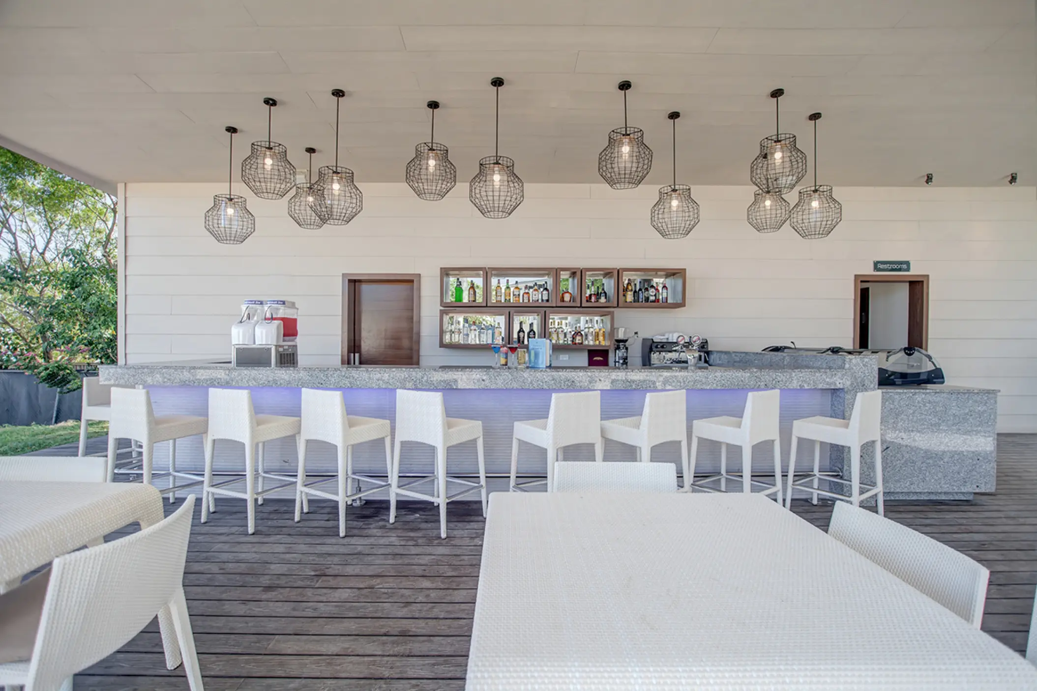 Diamond Beach Bar with white stools and modern pendant lights at Royalton Hideaway Negril