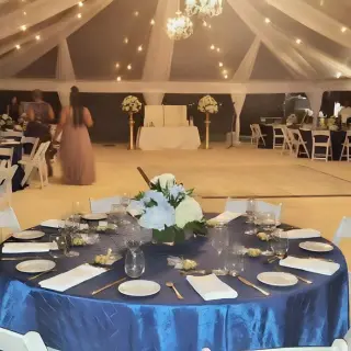 Wedding reception under a draped tent with blue linens and string lights at Royalton Hideaway Negril