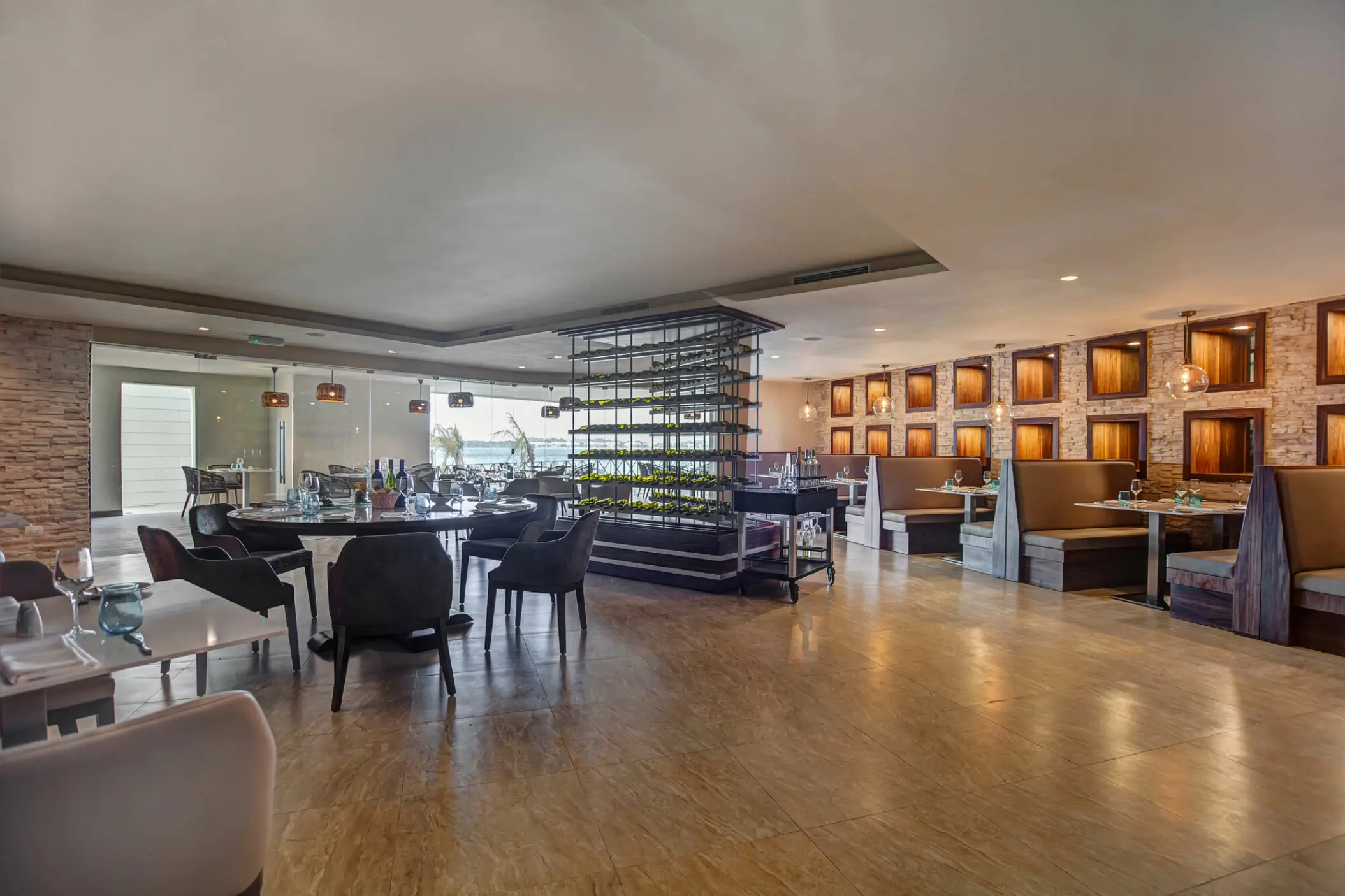 Dorado restaurant dining room with booth seating and wine rack at Royalton Hideaway Negril, Negril