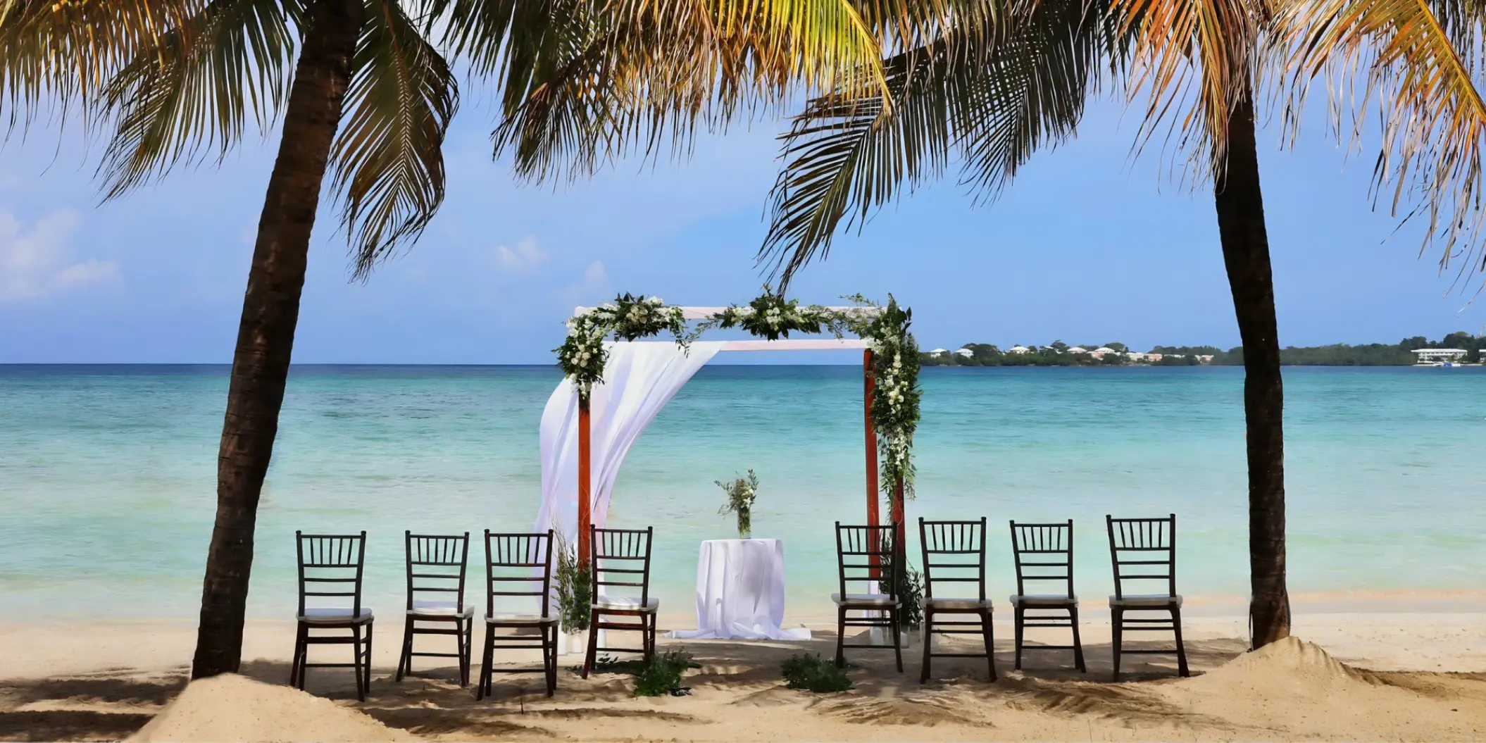Beachfront wedding ceremony setup under palm trees at Royalton Hideaway Negril, Jamaica
