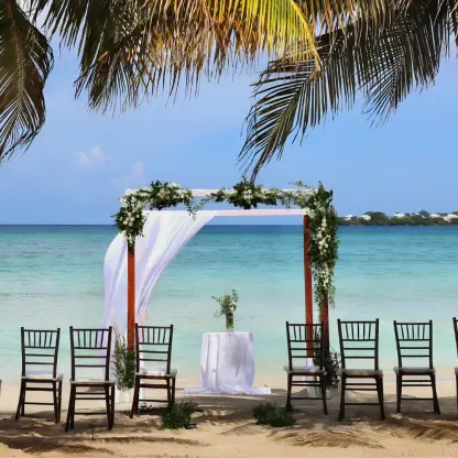 Beachfront wedding ceremony setup under palm trees at Royalton Hideaway Negril, Jamaica