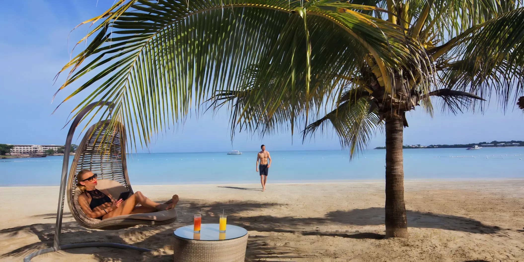 Woman relaxing in a hanging chair on the beach at Royalton Hideaway, Negril