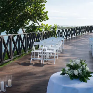 Oceanfront wedding ceremony terrace with white folding chairs at Royalton Hideaway Negril, Negril