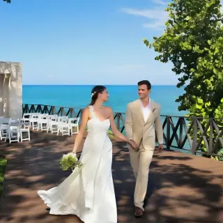 The bride and groom walking on Ocean Point terrace after their wedding ceremony at Royalton Hideaway Negril