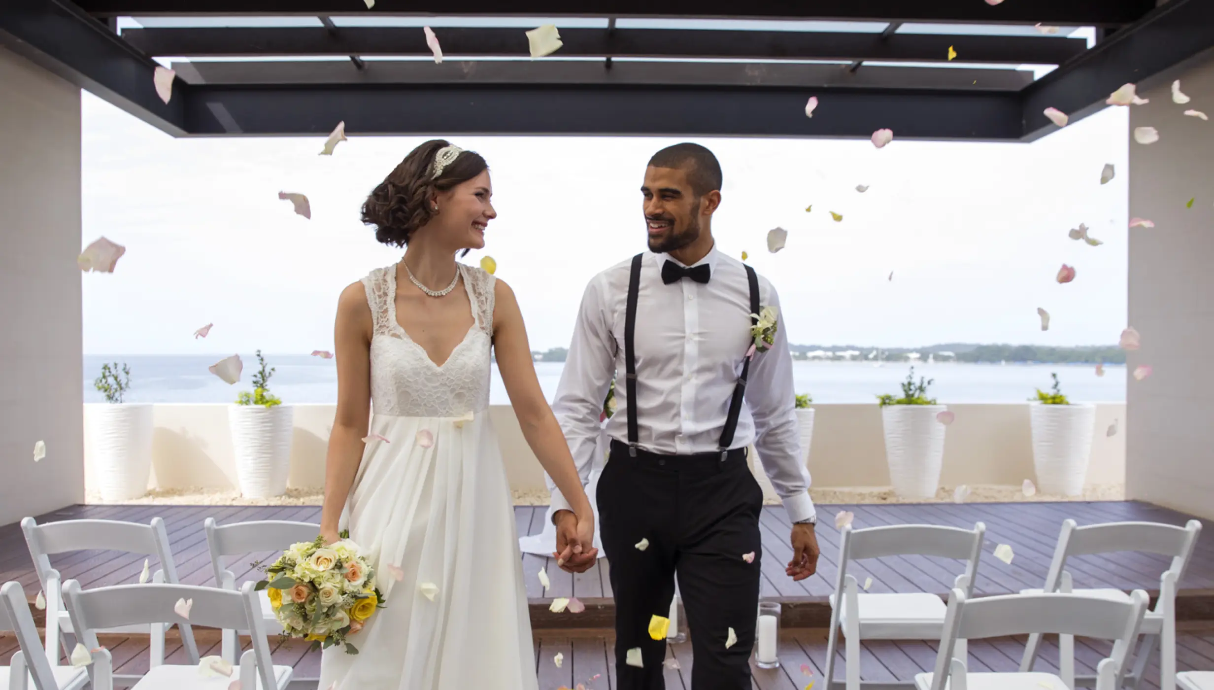 Bride and groom walking through flower petals at a Royalton Negril wedding, Negril