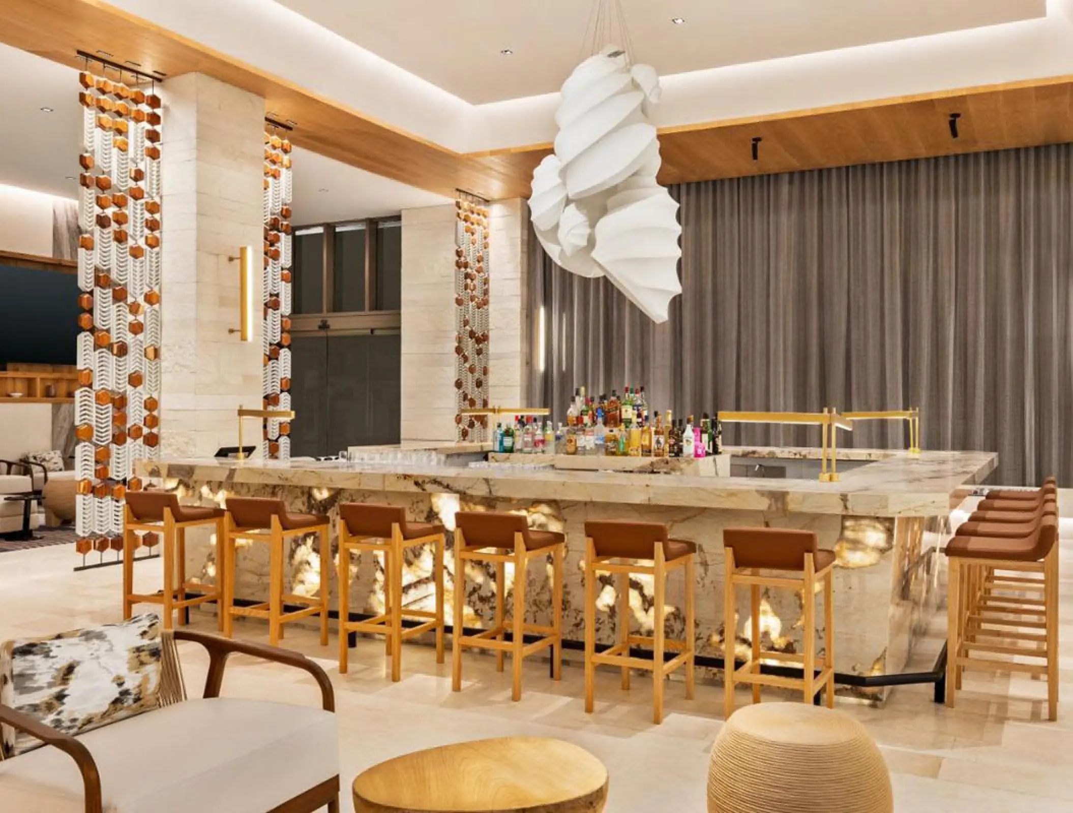 Modern bar with backlit stone and wooden stools at Hilton Cancun, Cancun