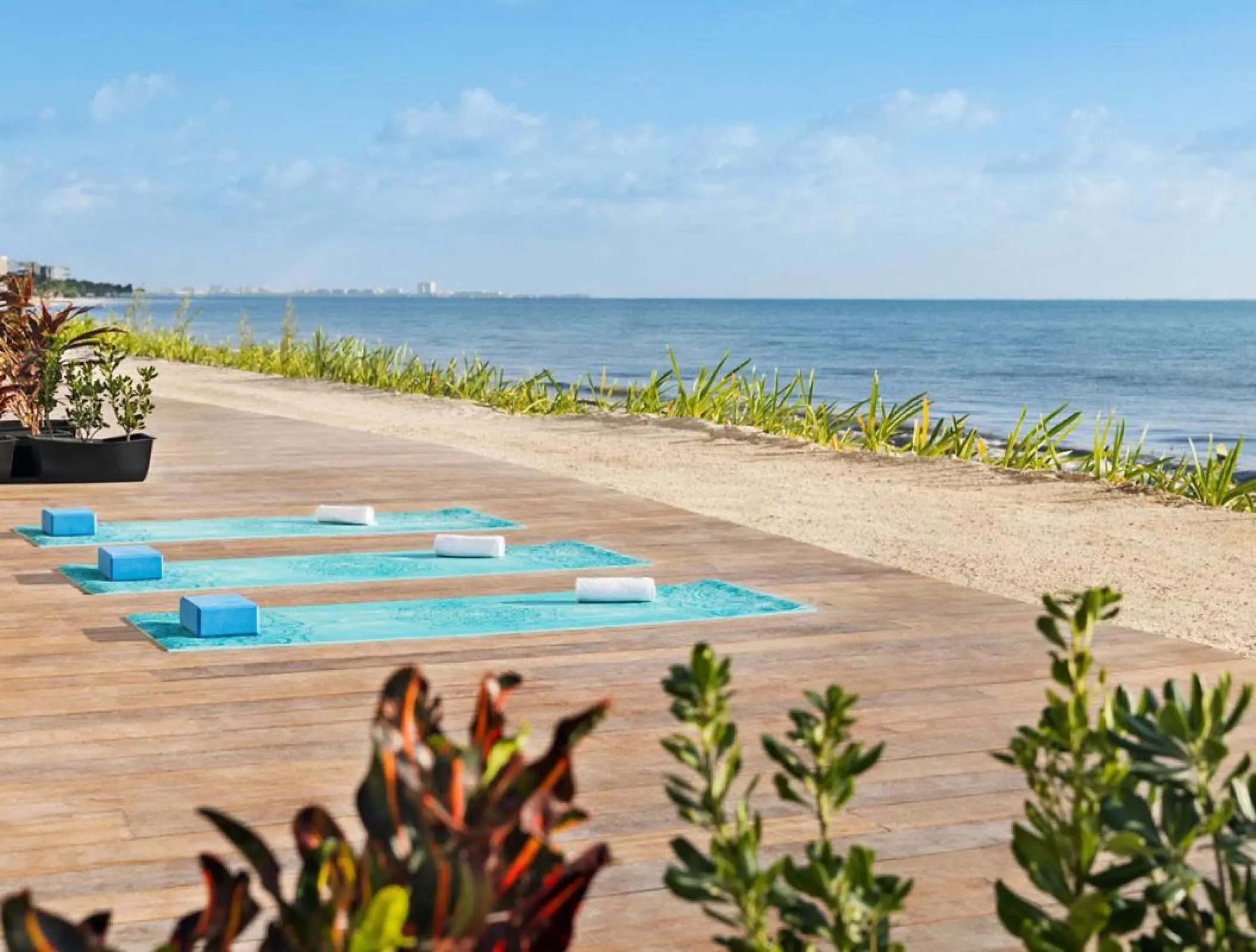 Yoga mats and blocks on a wooden deck overlooking the ocean at Hilton Cancun