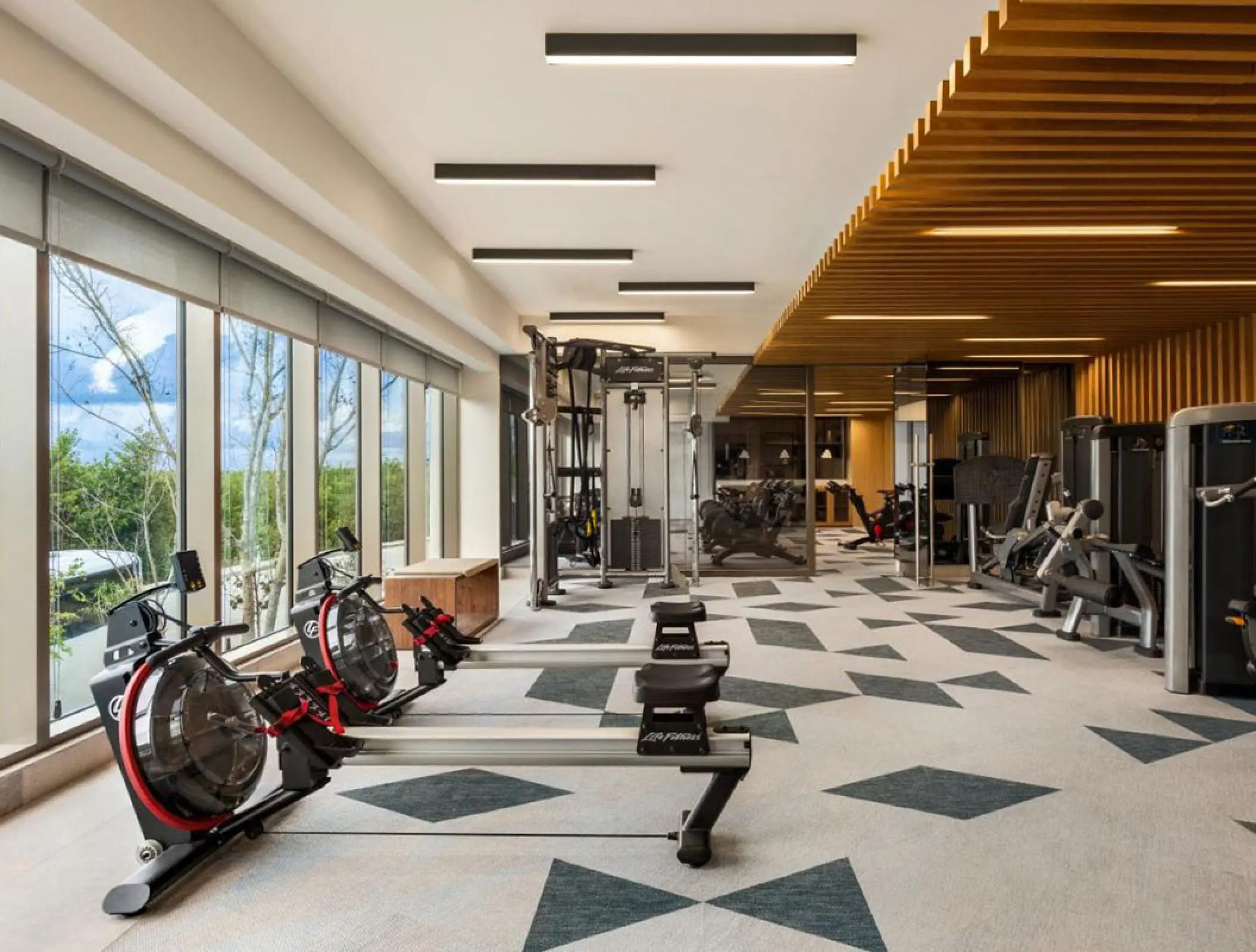 Modern fitness center with rowing machines and weight equipment at Hilton Cancun, Cancun