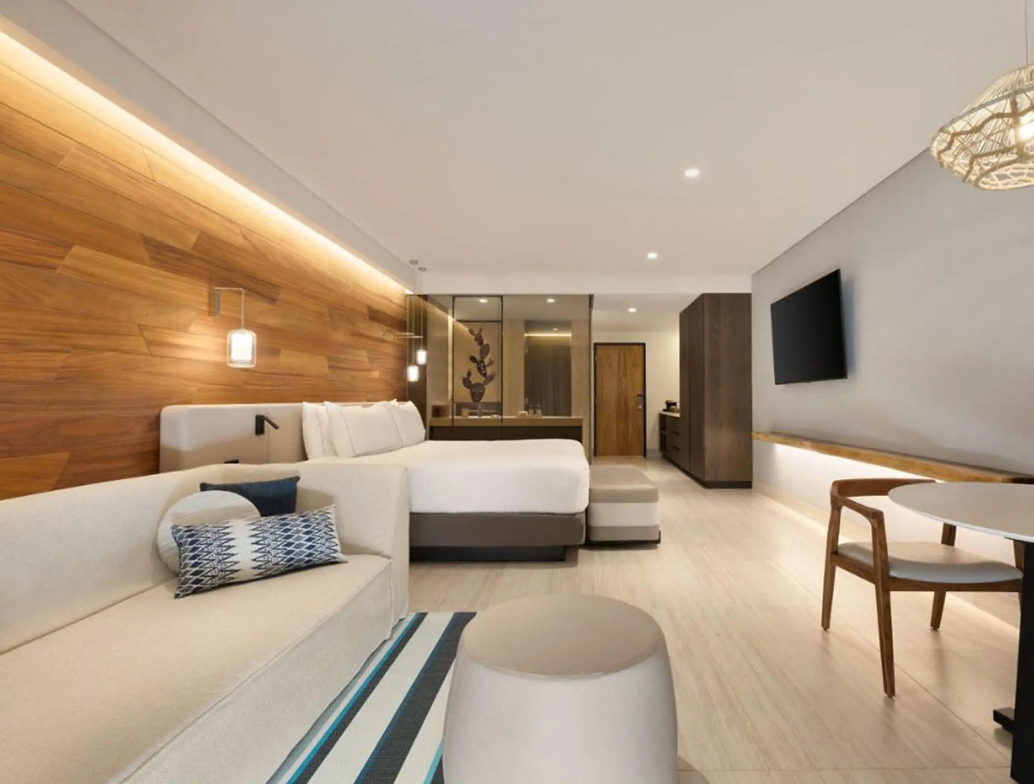 Junior suite with wood-paneled walls and a white sofa at Hilton Cancun, Cancun