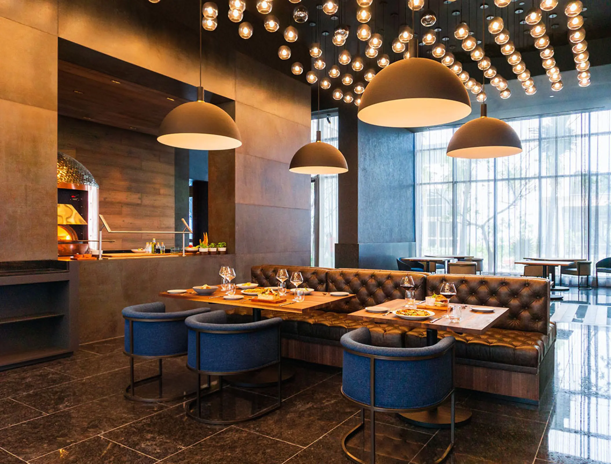 Modern indoor restaurant with booth seating and globe pendant lighting at Hilton Cancun, Cancun